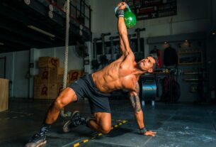 man in black shorts and black tank top doing push up