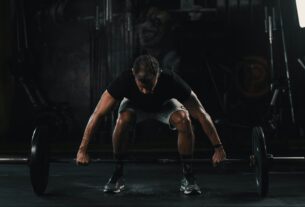 man in black tank top and black shorts doing push up